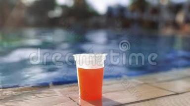女人游泳到游泳池的边缘，取新鲜的果汁，喝它，然后游泳离开，阳光明媚的一天在游泳池里。